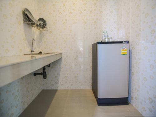 a small refrigerator in a room with a fan at Baan Yokmhanee in Hua Hin