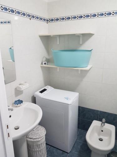 a white bathroom with a sink and a toilet at Casa Vacanza La Conchiglia in Monopoli