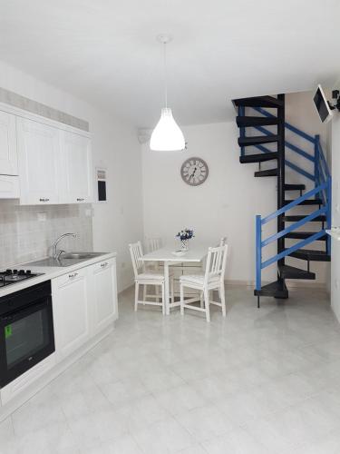 a kitchen with a table and a blue spiral staircase at Casa Vacanza La Conchiglia in Monopoli
