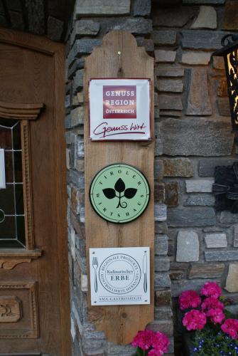 a wall with a clock on the side of a building at Gasthof Tannen - Alm in Stummerberg