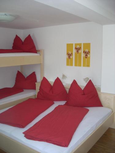 エーベン・イム・ポンガウにあるSimonlehengutのベッドルーム1室(赤い枕、二段ベッド2組付)