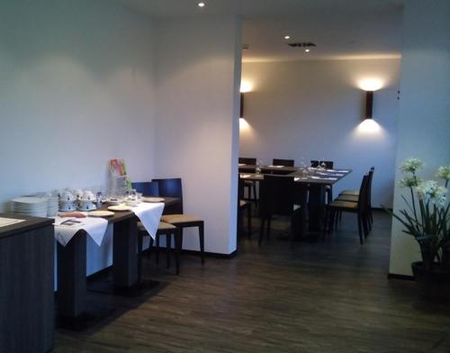 a dining room with tables and chairs in a restaurant at Reit- und Sporthotel Eibenstock in Eibenstock