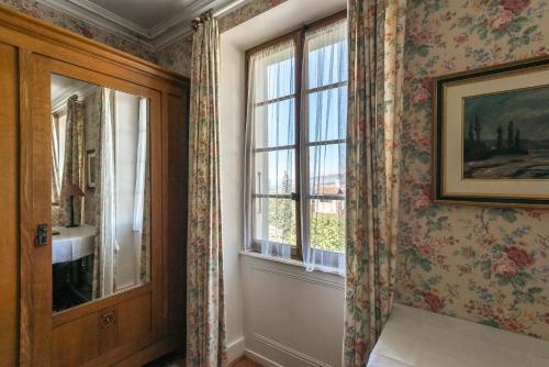 a room with a window with floral wallpaper at Swiss Historic Hotel Masson in Montreux