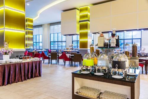 a restaurant with a counter with food on it at Grand Palazzo Hotel - SHA Extra Plus in Pattaya