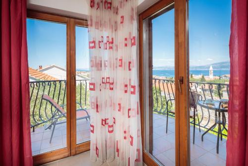 a balcony with sliding glass doors with a view of the ocean at Apartments Judita in Supetar