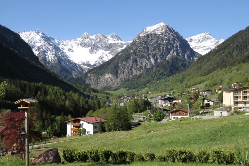a village in a valley with snow capped mountains at Haus Flua in Brand