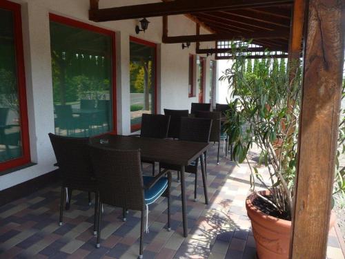 a patio with a table and chairs and plants at Kőrös Hotel in Kiskőrös