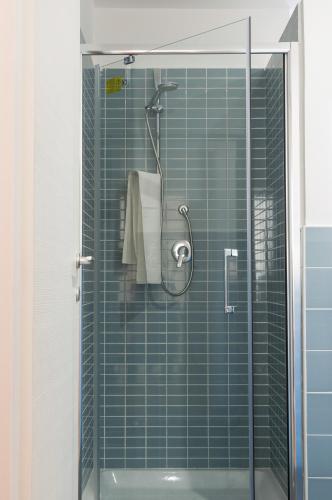 a bathroom with a shower with green tiles at Quiet Home Terracina Apartments in Terracina
