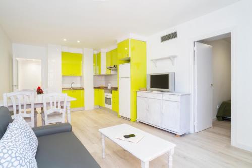 a white refrigerator freezer sitting in a kitchen at Apartamentos InterSalou Priorat in Salou