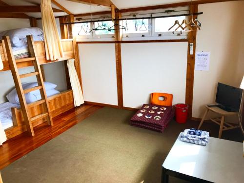 a living room with a bunk bed and a table at Minshuku Yakushima in Yakushima