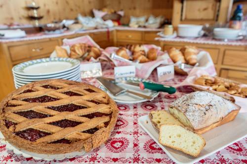 a table topped with bread and a pie and pastries at Hotel La Montanina in Alleghe