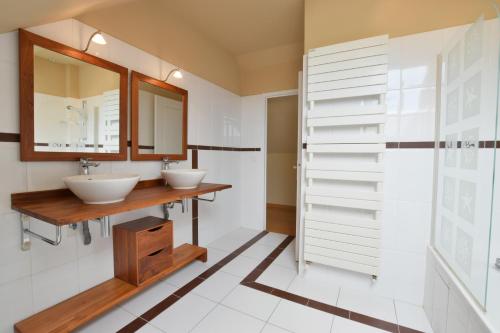 een badkamer met 2 wastafels en een spiegel bij Domaine Uraveni in Theix