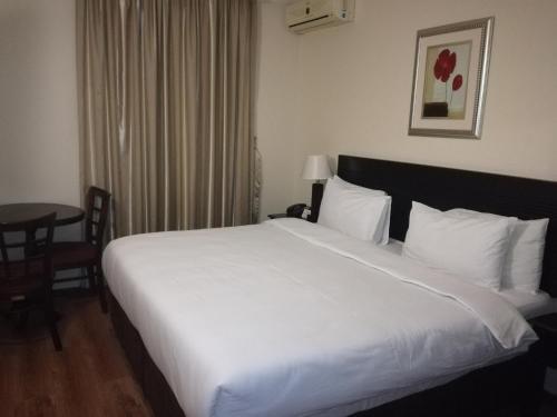 a large white bed in a hotel room at Regal Inn Ballito in Ballito