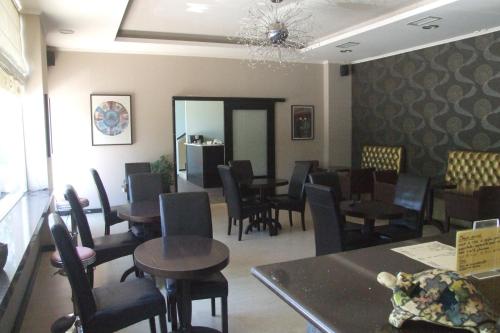 a dining room with tables and chairs and a waiting area at Hotel Georgios in Rio