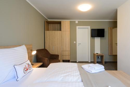 a hotel room with a bed and a chair at Pension Kral in Rust