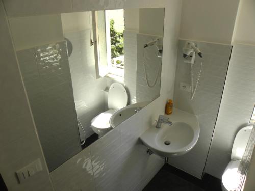 y baño con lavabo, aseo y espejo. en Albergo La Neigra, en Sestri Levante