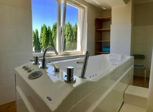 a large white bathroom with a sink and a window at Hotel *** NAT Jarosławiec in Jarosławiec