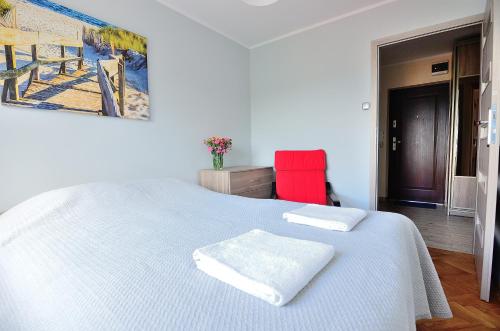 ソポトにあるVictus Apartamenty, Apartament Jantarのベッドルーム1室(白いベッド1台、タオル2枚付)