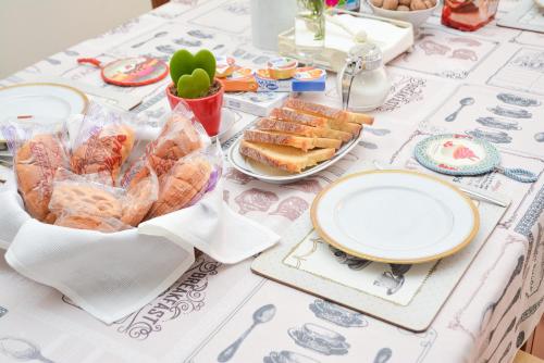 uma mesa com uma toalha de mesa com sanduíches e pratos em Lian Room B&B em Caserta