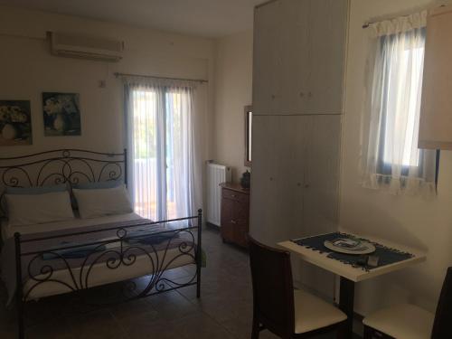 a bedroom with a bed and a table and window at Serifos Palace in Livadakia