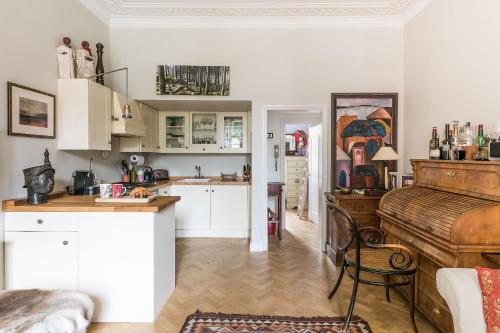 a kitchen with a table and a piano in a room at The Hummingbird - Stylish 1-Bed by Kensington Gardens in London