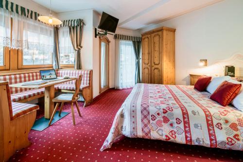 Pokój hotelowy z łóżkiem i biurkiem w obiekcie Hotel La Montanina w Alleghe