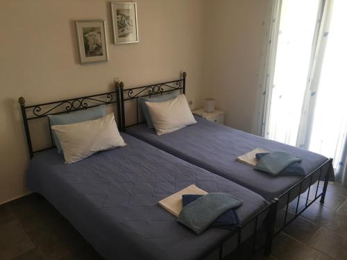a bedroom with a bed with blue sheets and pillows at Serifos Palace in Livadakia