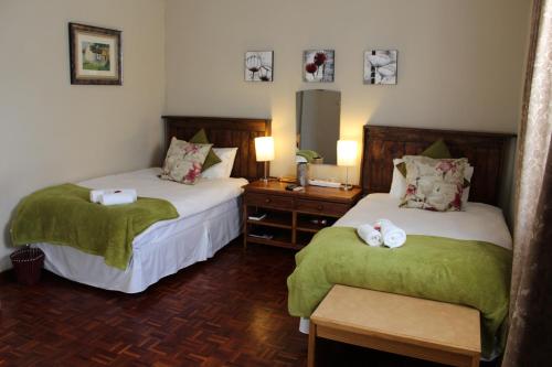 a hotel room with two beds with towels on them at The Hamlet Country Lodge in Ceres