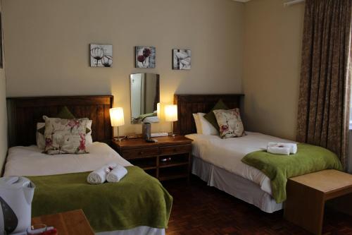 a hotel room with two beds and a mirror at The Hamlet Country Lodge in Ceres