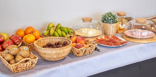 a table with baskets of fruits and vegetables on it at Hotel Can Pamplona in Vic