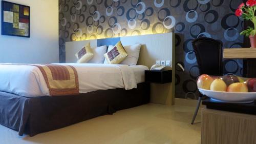 Hotel Jolin في ماكاسار: غرفة في الفندق بها سرير ووعاء من الفواكه