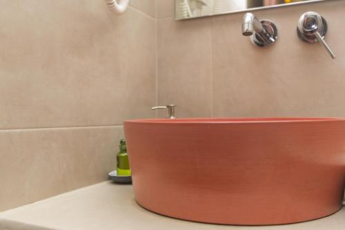 a bathroom with a red sink in a bathroom at Amalthia Luxury Studios in Naxos Chora