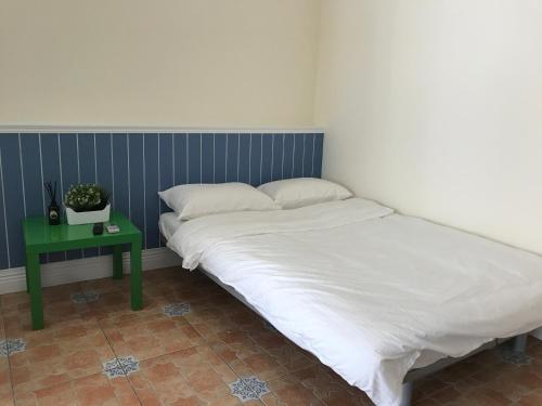 a bed in a room with a green side table at Chill Chill House in Shimen