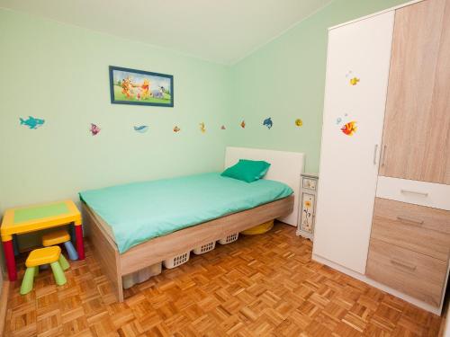 a small bedroom with a bed and a wooden floor at Apartments Marija in Vir