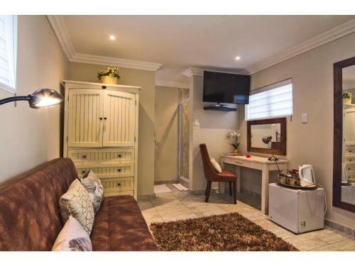 a living room with a couch and a kitchen at La Loggia Bed and Breakfast in Durban