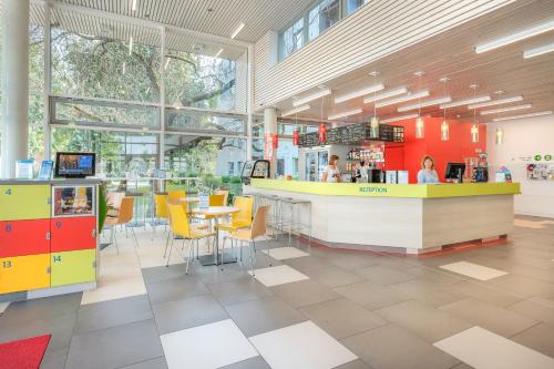 a restaurant with a counter and tables and chairs at martas Gästehäuser Hauptbahnhof Berlin in Berlin