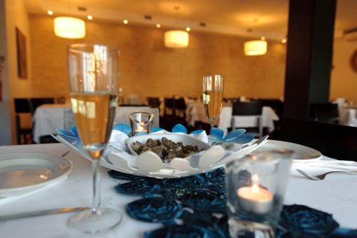 a table with a plate of food and two wine glasses at Sever Rio Hotel in Marvão