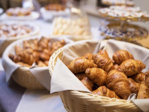 a table with two baskets of pastries and other foods at Hotel Cube in Ravenna