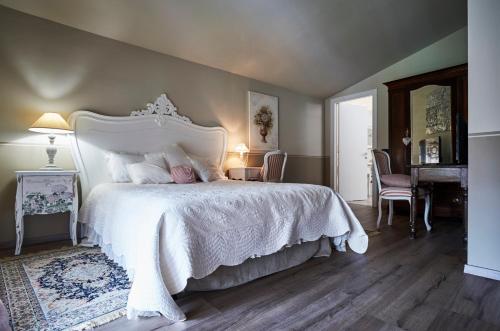 a bedroom with a large white bed and a piano at CR BnB Rozzano in Rozzano