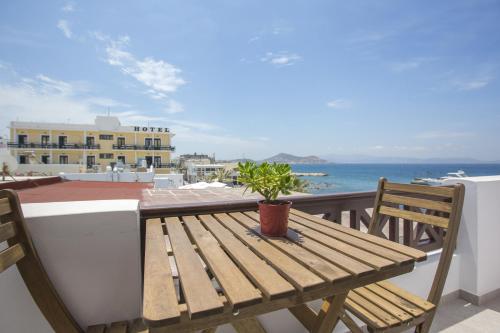 a wooden bench sitting on a balcony overlooking the ocean at Amalthia Luxury Studios in Naxos Chora