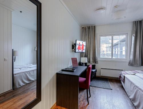 a hotel room with a desk and a mirror at Vollan Gjestestue in Nordkjosbotn