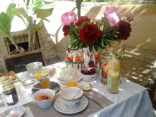 a table with a white table cloth with flowers and juice at La Maison de Charlie in Vaugines