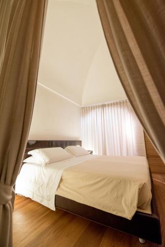 a bedroom with a white bed with curtains at Dimora Intini in Noci