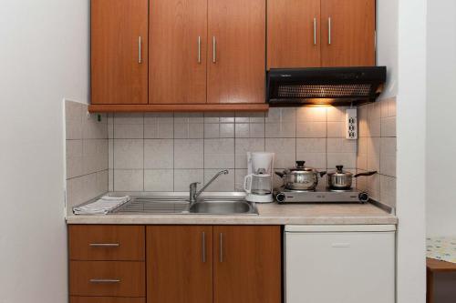 a kitchen with a sink and a stove and cabinets at Saonisos in Kamariotissa