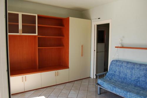 una sala de estar con una silla azul y estanterías en Solanha monolocale n.4 en Cavo