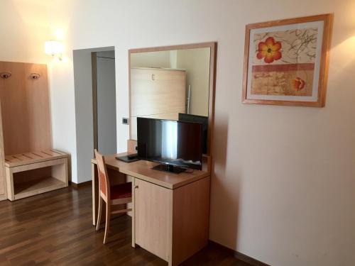 a room with a desk with a television on it at Hotel Capo Reamol in Limone sul Garda