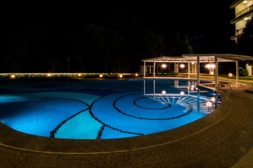 a swimming pool at night with a gazebo at Park Regis Goa in Arpora