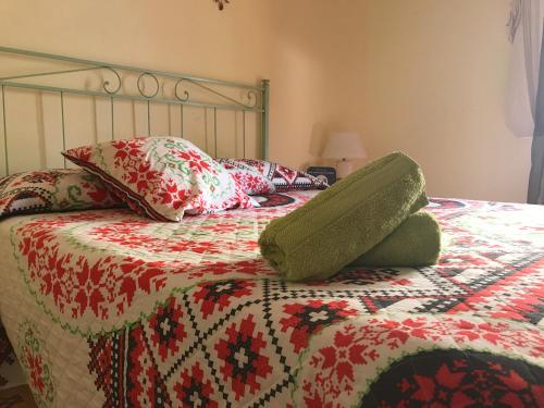 - une chambre avec un lit doté d'une couette rouge et verte dans l'établissement Terry, Camera Vacanze Alghero, à Alghero