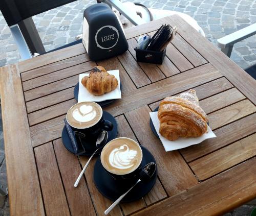 a table with cups of coffee and croissants on it at Viverenumana in Numana