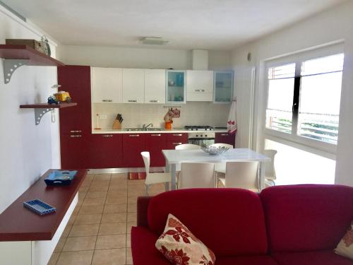 a living room with a red couch and a kitchen at Gardasol Holiday Apartment in Arco